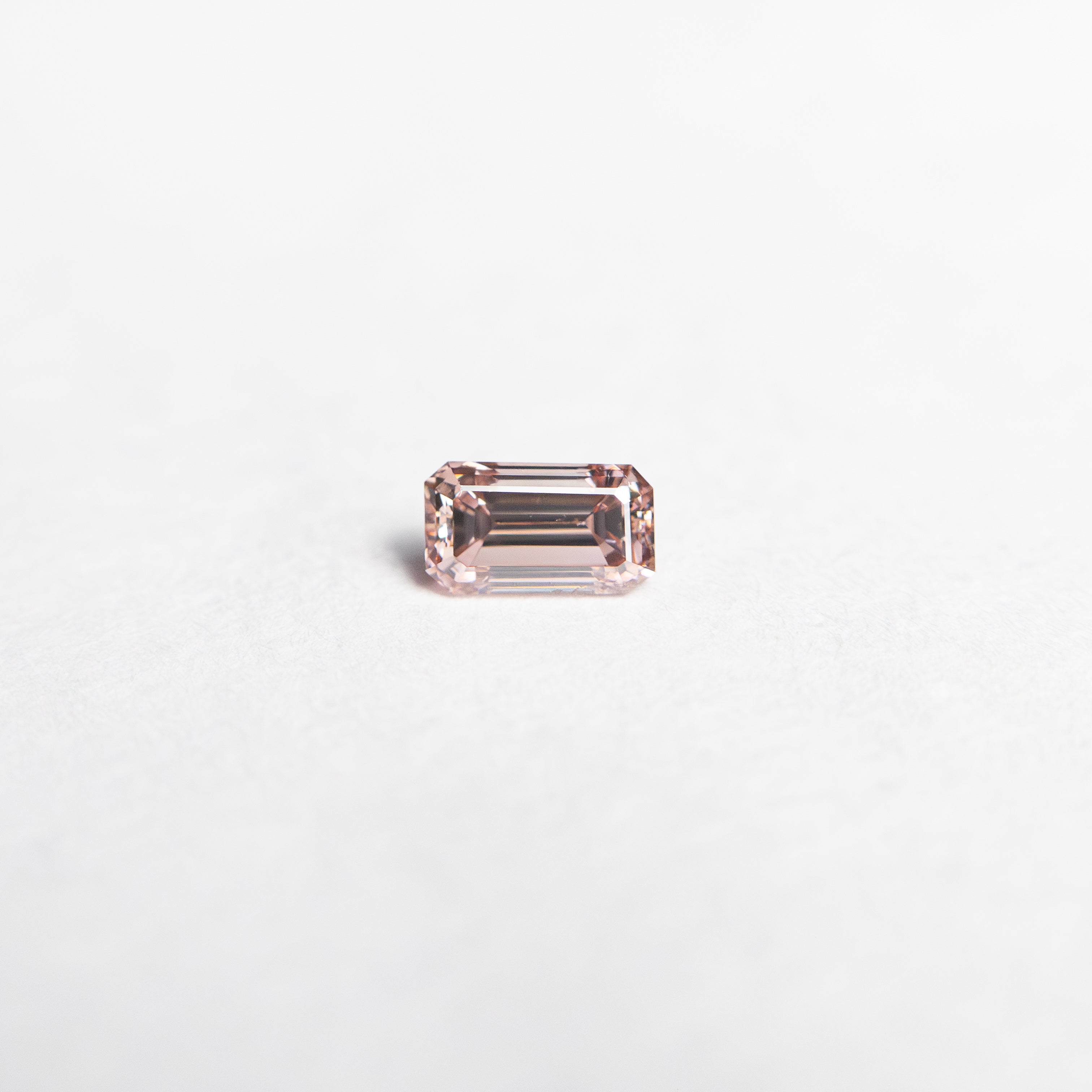 The 0.12ct 3.42x1.96x1.76mm VS1 Fancy Intense Orangy Pink Cut Corner Rectangle Step Cut 24108-01 by East London jeweller Rachel Boston | Discover our collections of unique and timeless engagement rings, wedding rings, and modern fine jewellery.