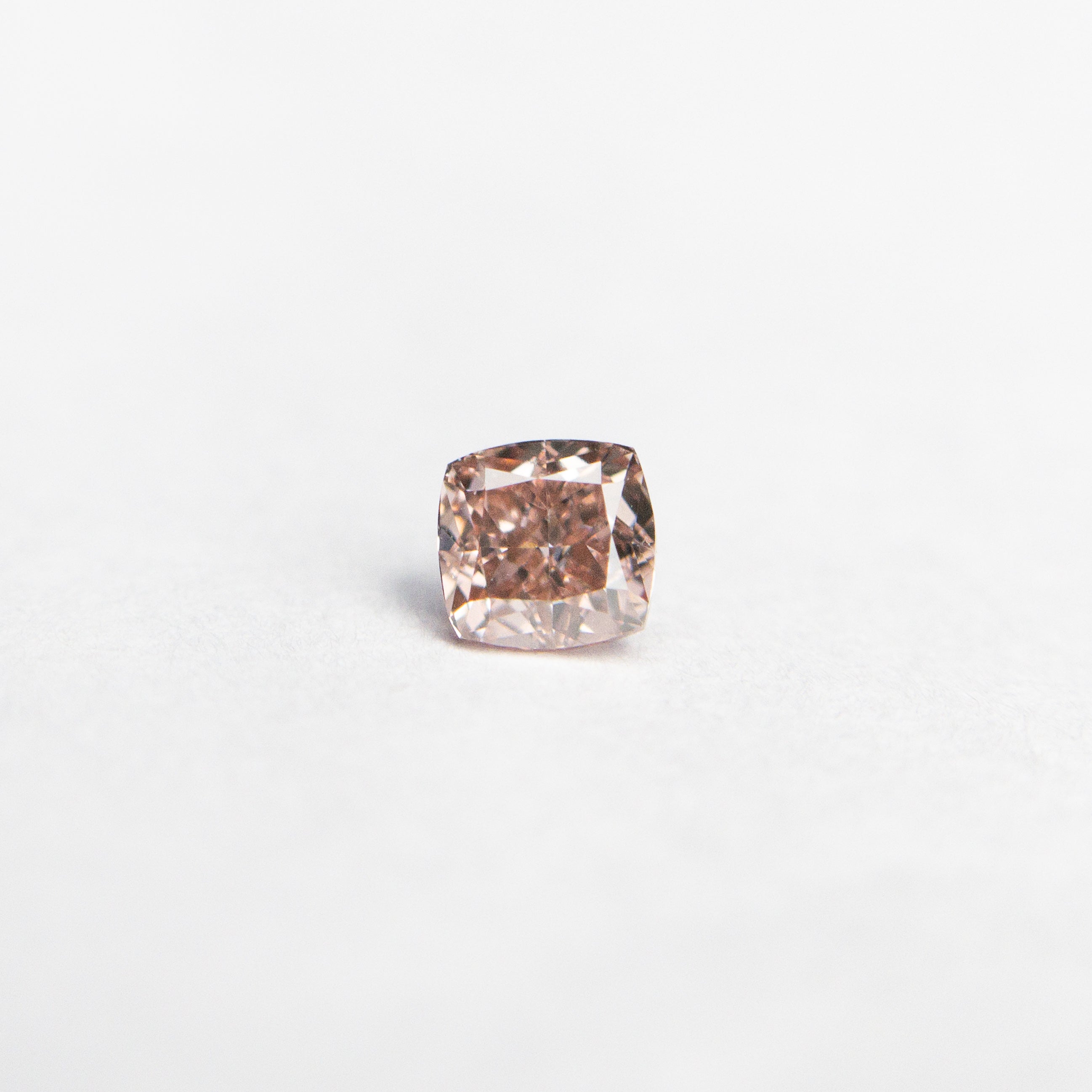 The 0.13ct 2.79x2.72x1.87mm GIA Fancy Orangy Pink Cushion Brilliant 🇦🇺 24100-01 by East London jeweller Rachel Boston | Discover our collections of unique and timeless engagement rings, wedding rings, and modern fine jewellery.