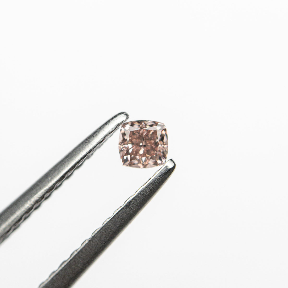 The 0.13ct 2.79x2.72x1.87mm GIA Fancy Orangy Pink Cushion Brilliant 🇦🇺 24100-01 by East London jeweller Rachel Boston | Discover our collections of unique and timeless engagement rings, wedding rings, and modern fine jewellery.