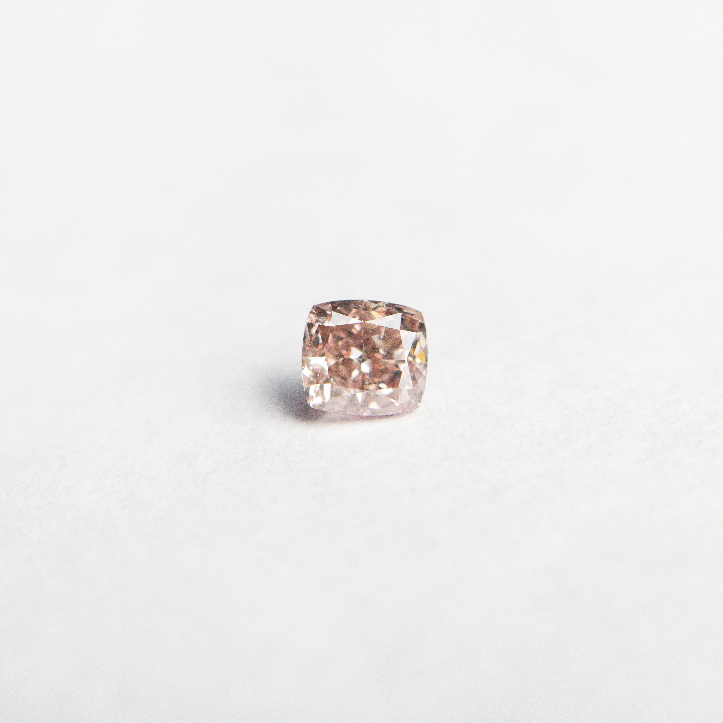 The 0.13ct 2.86x2.63x1.93mm GIA Fancy Orangy Pink Cushion Brilliant 🇦🇺 24101-01 by East London jeweller Rachel Boston | Discover our collections of unique and timeless engagement rings, wedding rings, and modern fine jewellery.
