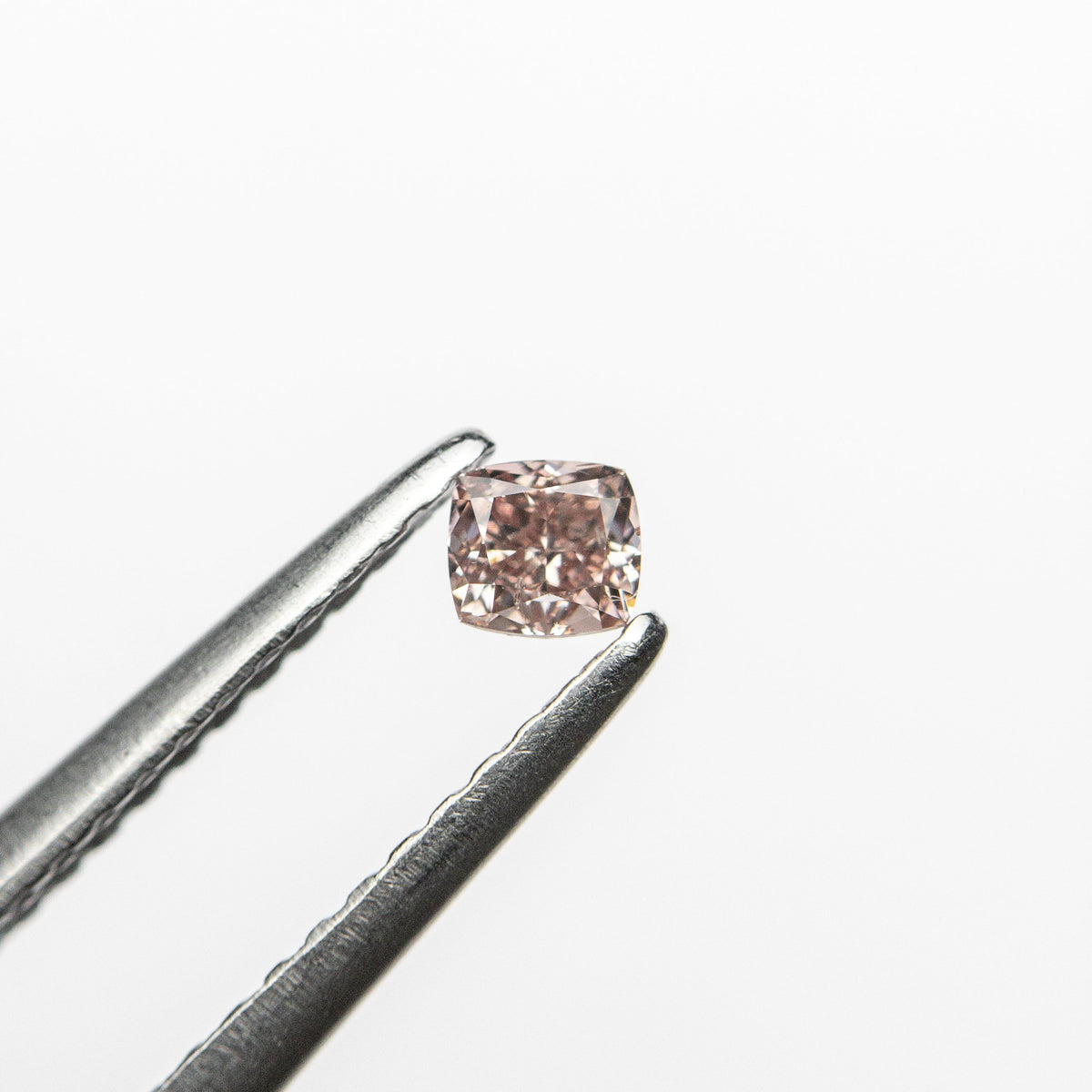 The 0.13ct 2.86x2.63x1.93mm GIA Fancy Orangy Pink Cushion Brilliant 🇦🇺 24101-01 by East London jeweller Rachel Boston | Discover our collections of unique and timeless engagement rings, wedding rings, and modern fine jewellery.
