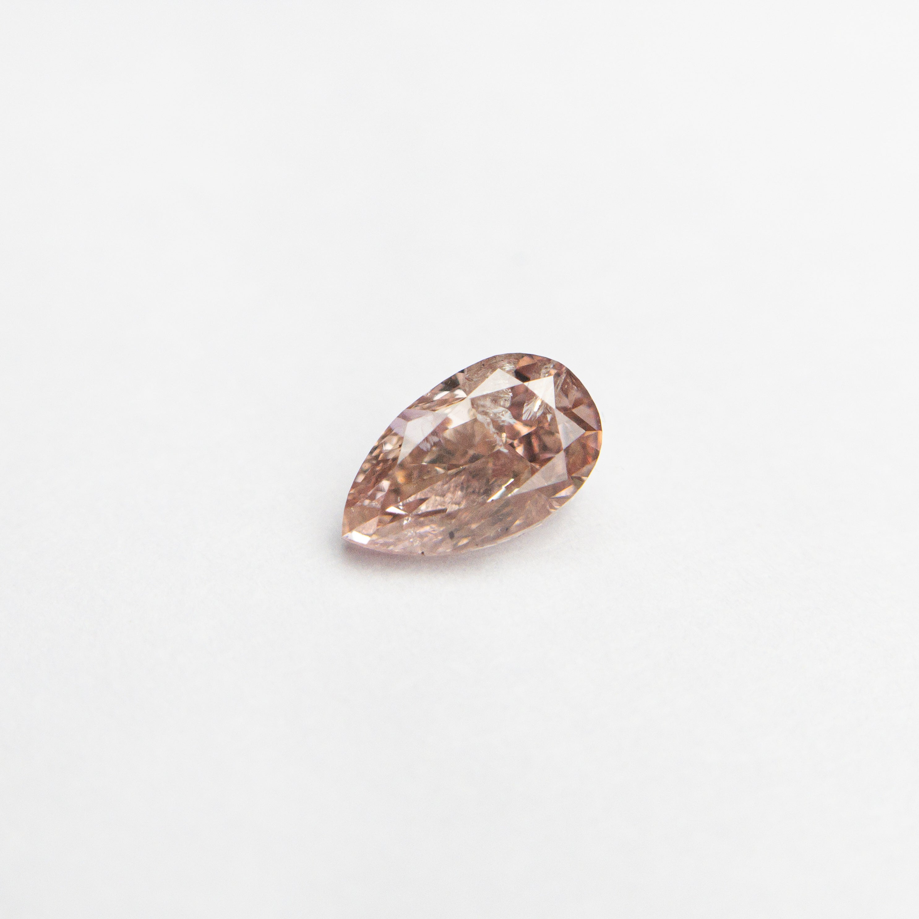 The 0.26ct 4.93x2.92x2.15mm Fancy Pink Pear Brilliant 24106-01 by East London jeweller Rachel Boston | Discover our collections of unique and timeless engagement rings, wedding rings, and modern fine jewellery.