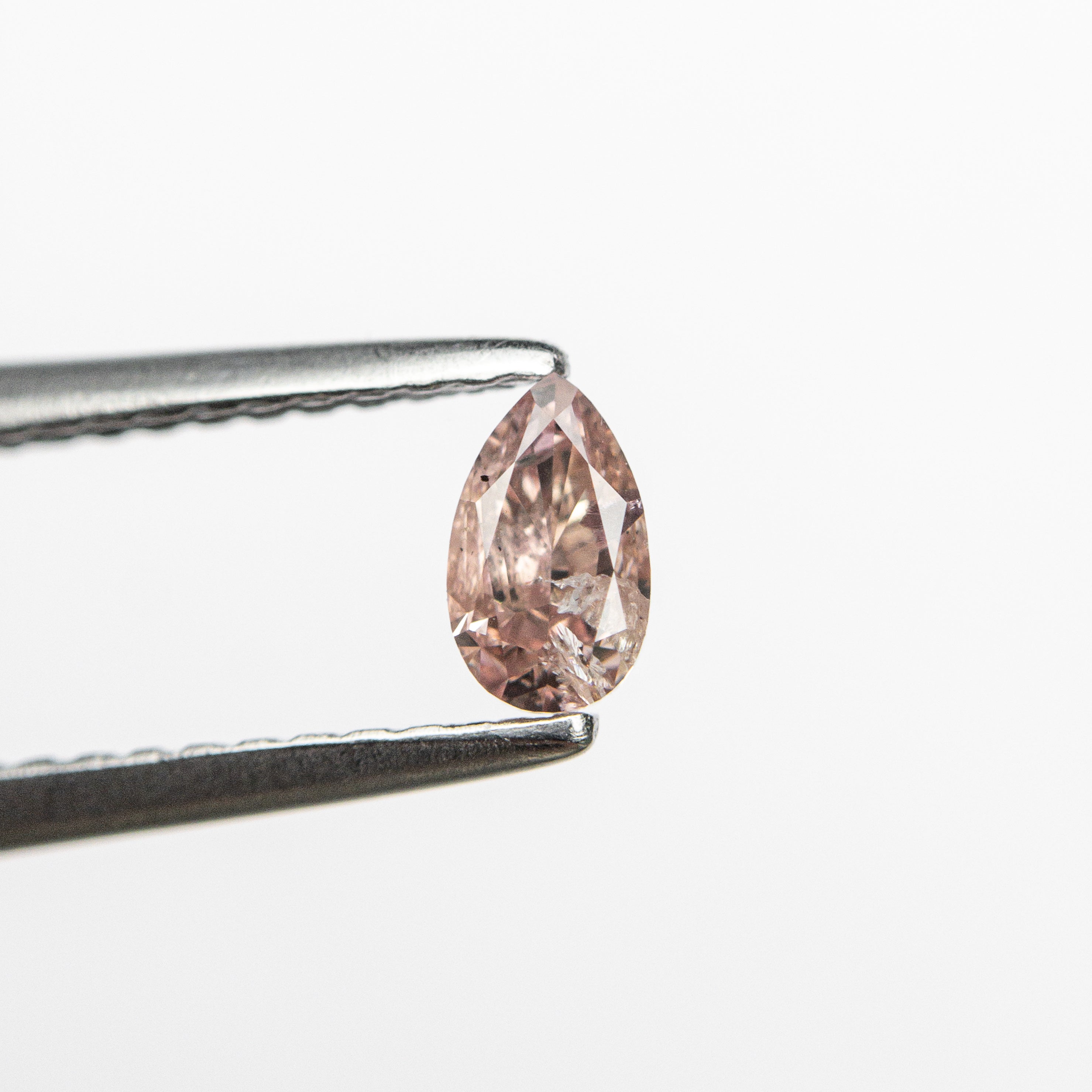 The 0.26ct 4.93x2.92x2.15mm Fancy Pink Pear Brilliant 24106-01 by East London jeweller Rachel Boston | Discover our collections of unique and timeless engagement rings, wedding rings, and modern fine jewellery.