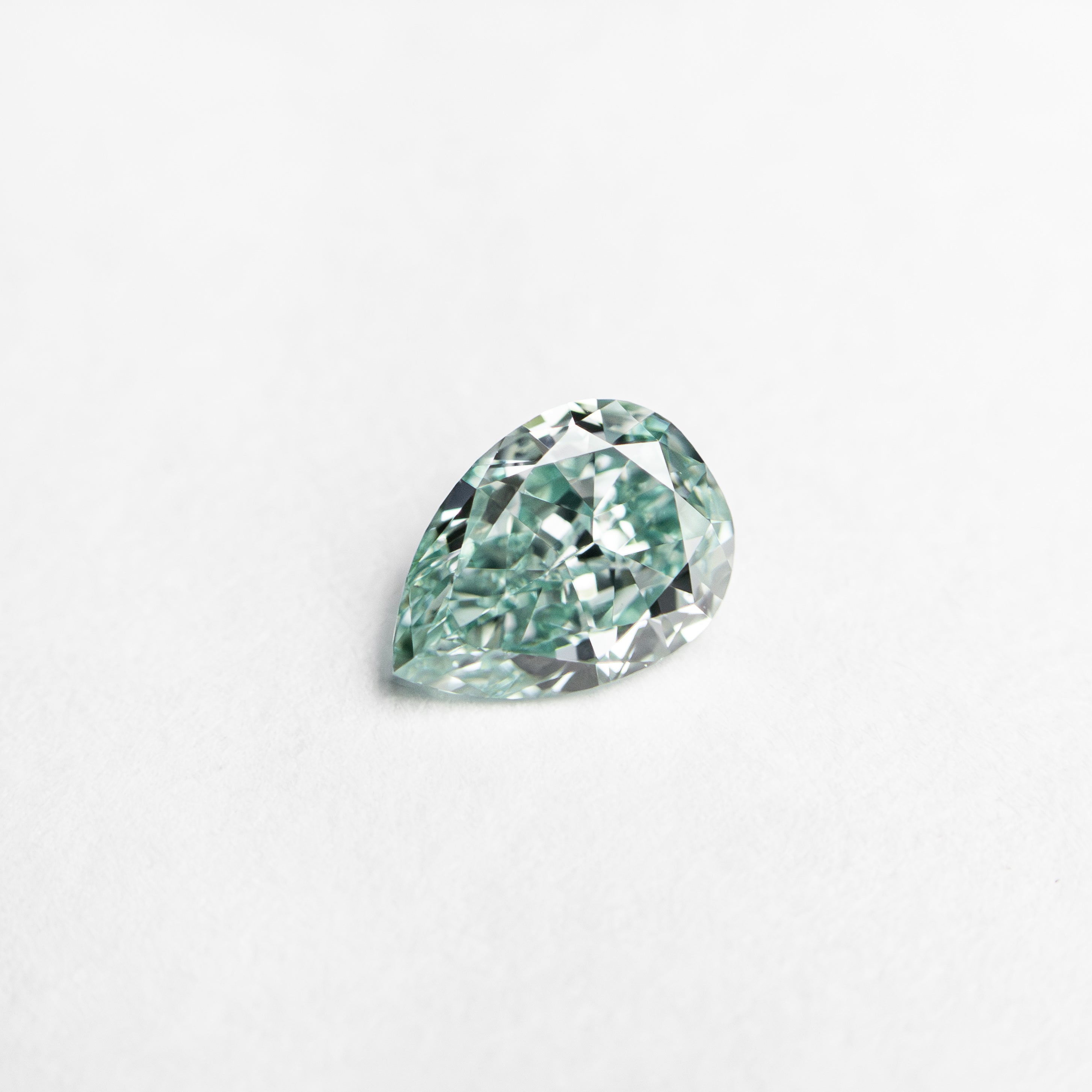 The 0.32ct 5.48x3.95x2.17mm GIA VVS2 Fancy Vivid Bluish Green Pear Brilliant 24131-01 by East London jeweller Rachel Boston | Discover our collections of unique and timeless engagement rings, wedding rings, and modern fine jewellery.