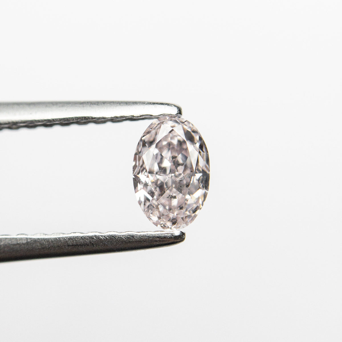 The 0.40ct 5.38x3.60x2.59mm GIA I1 Fancy Light Pink Oval Brilliant 24094-01 by East London jeweller Rachel Boston | Discover our collections of unique and timeless engagement rings, wedding rings, and modern fine jewellery.