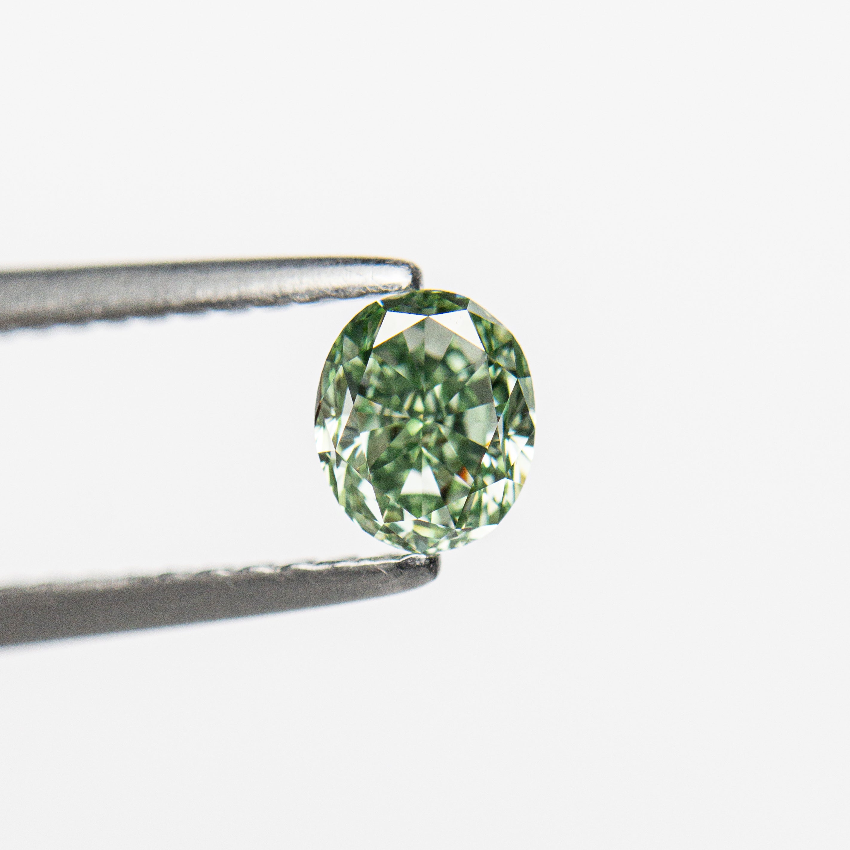 The 0.46ct 4.71x3.96x2.93mm GIA VS2 Fancy Vivid Green Oval Brilliant 24135-01 by East London jeweller Rachel Boston | Discover our collections of unique and timeless engagement rings, wedding rings, and modern fine jewellery.
