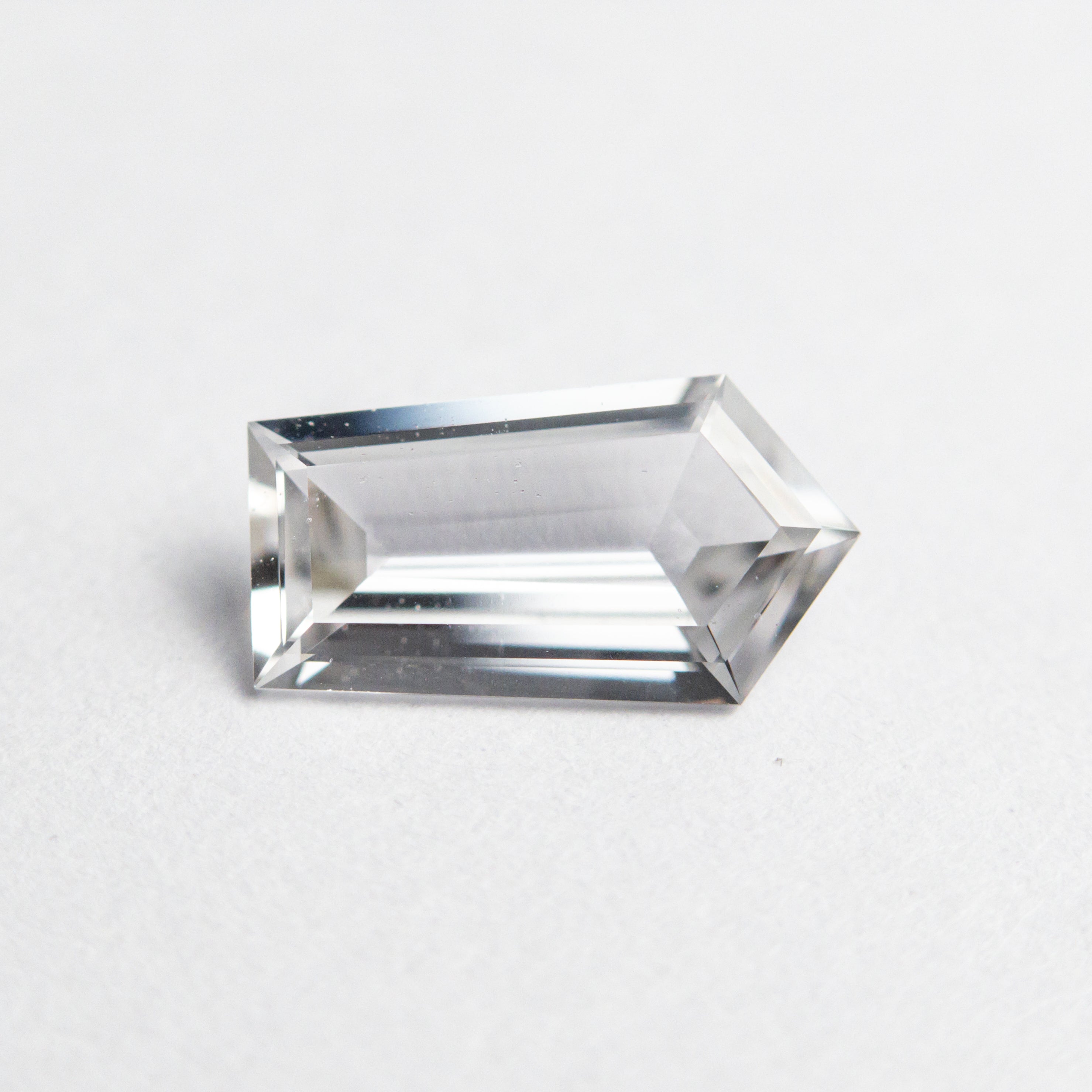 The 0.91ct 8.87x4.84x2.38mm Shield Step Cut Sapphire 22835-01 by East London jeweller Rachel Boston | Discover our collections of unique and timeless engagement rings, wedding rings, and modern fine jewellery.