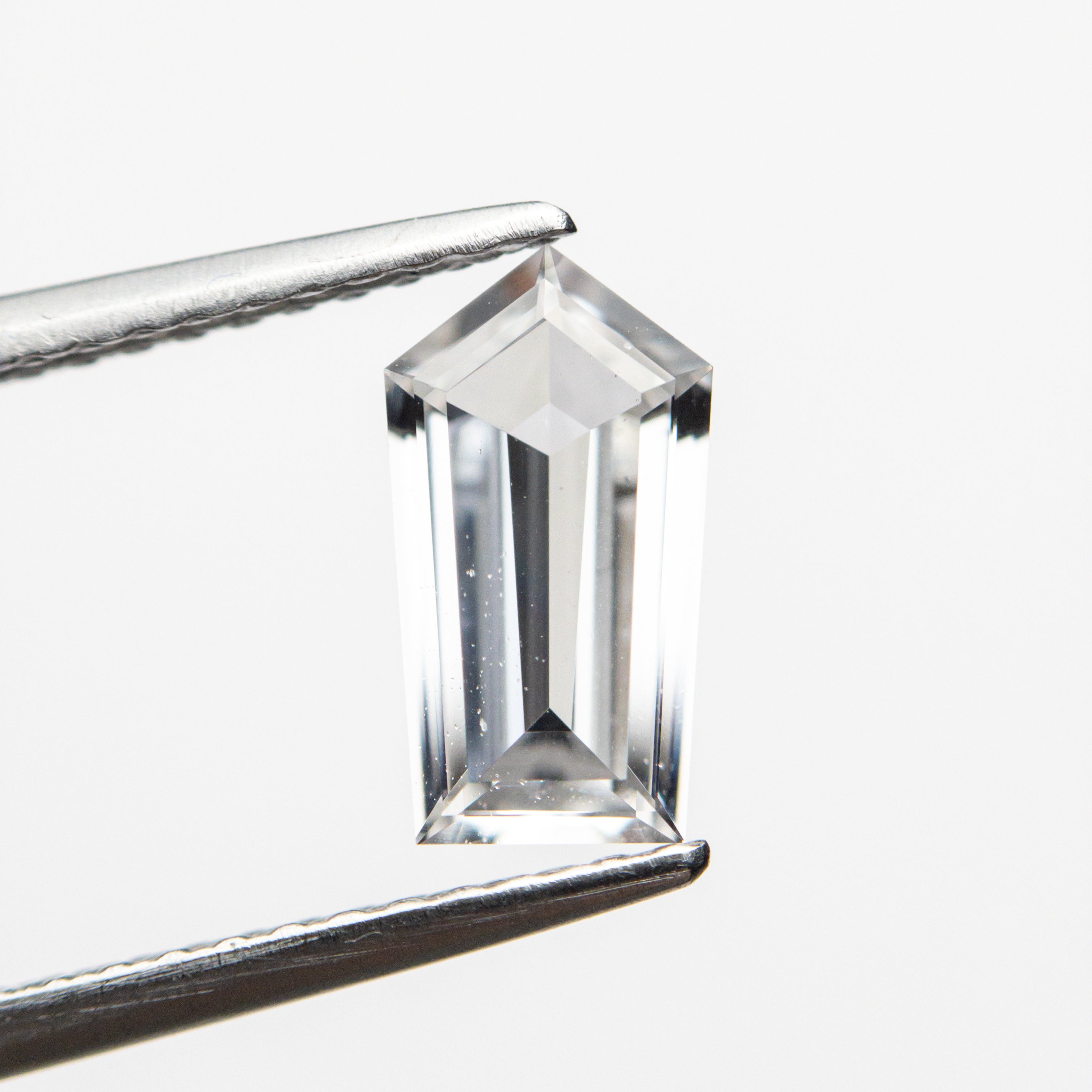 The 0.91ct 8.87x4.84x2.38mm Shield Step Cut Sapphire 22835-01 by East London jeweller Rachel Boston | Discover our collections of unique and timeless engagement rings, wedding rings, and modern fine jewellery.