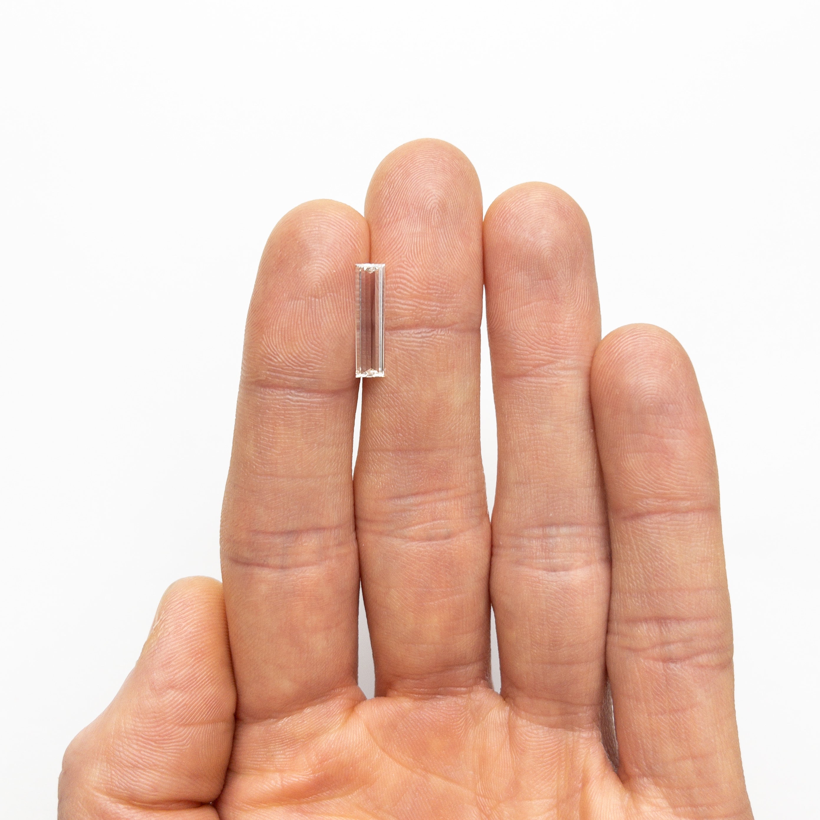The 1.10ct 15.57x4.14x1.48mm GIA VS1 J Baguette Step Cut 24305-01 by East London jeweller Rachel Boston | Discover our collections of unique and timeless engagement rings, wedding rings, and modern fine jewellery.