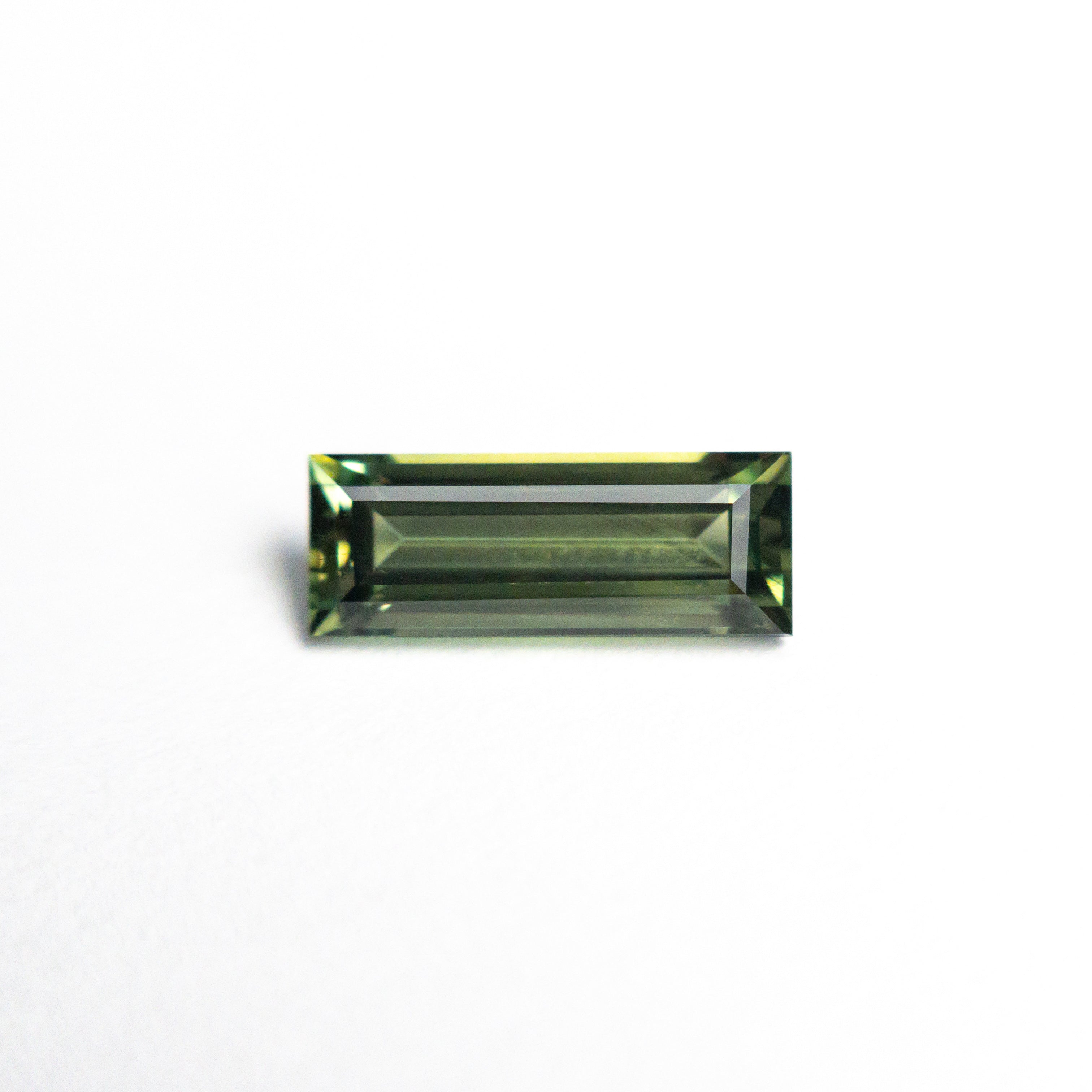 The 0.85ct 8.45x3.22x2.61mm Rectangle Step Cut Sapphire 25740-03 by East London jeweller Rachel Boston | Discover our collections of unique and timeless engagement rings, wedding rings, and modern fine jewellery.