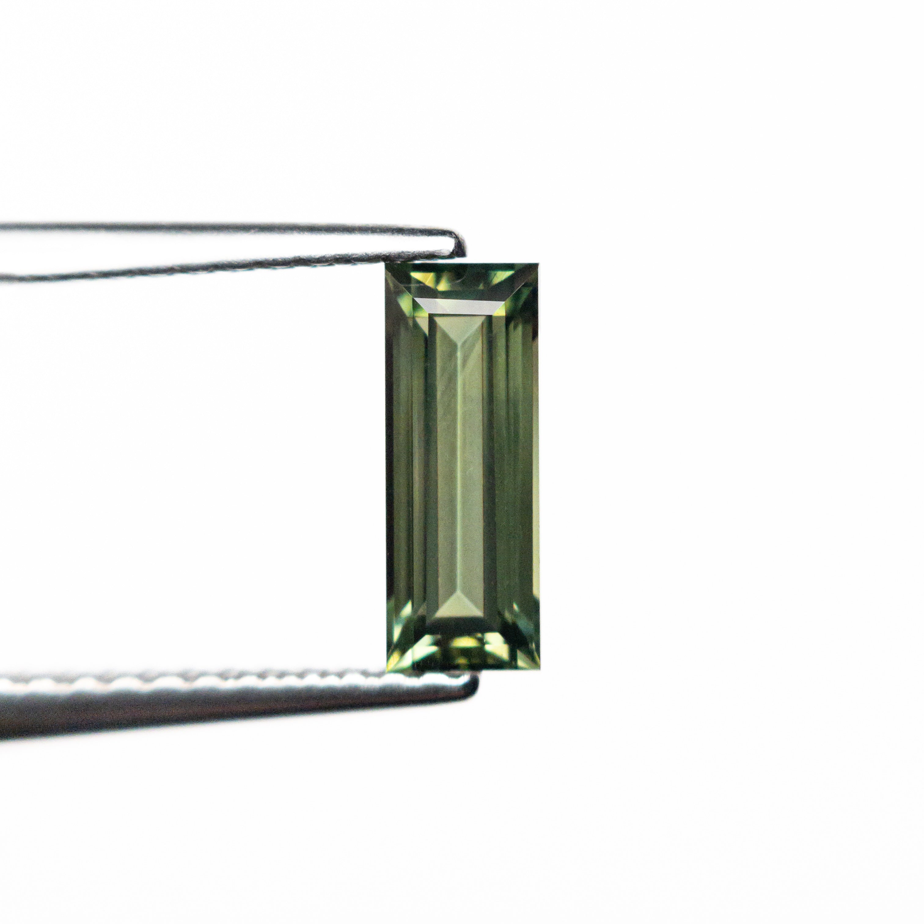 The 0.85ct 8.45x3.22x2.61mm Rectangle Step Cut Sapphire 25740-03 by East London jeweller Rachel Boston | Discover our collections of unique and timeless engagement rings, wedding rings, and modern fine jewellery.