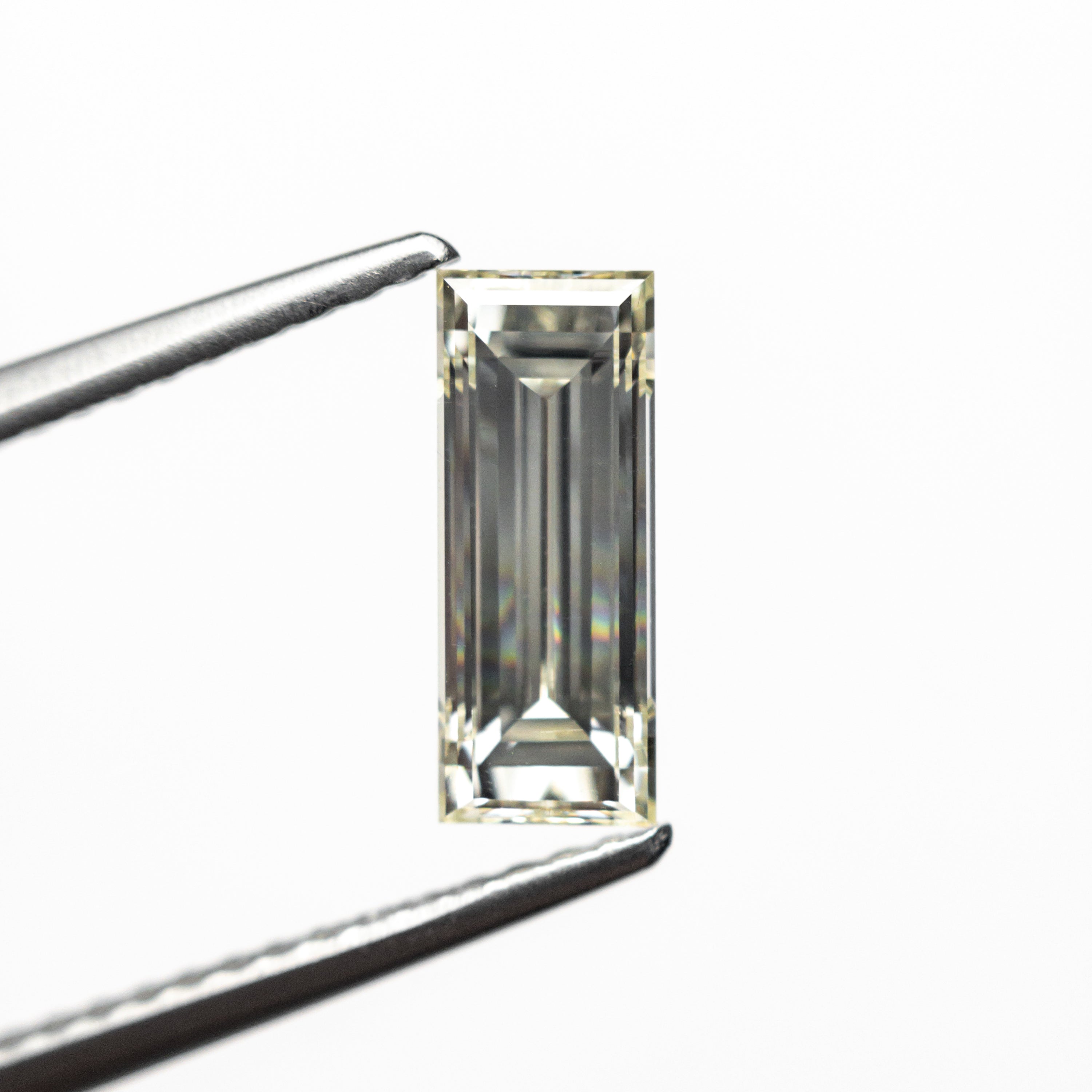 The 1.11ct 9.55x3.80x2.97mm VS2 O-P Baguette Step Cut 26124-02 by East London jeweller Rachel Boston | Discover our collections of unique and timeless engagement rings, wedding rings, and modern fine jewellery.