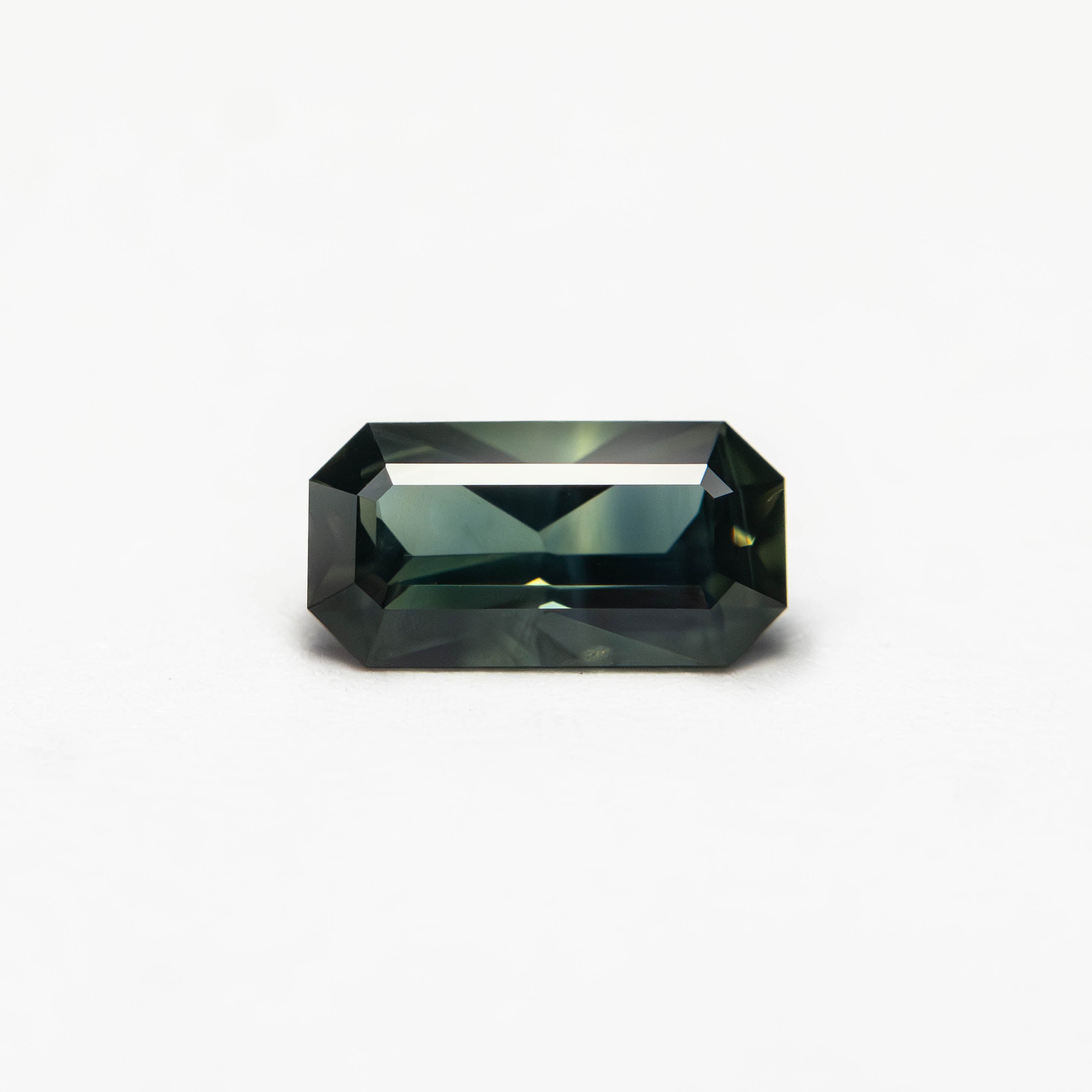The 0.60ct 6.93x3.63x2.58mm Cut Corner Rectangle Step Cut Sapphire 27336-39 by East London jeweller Rachel Boston | Discover our collections of unique and timeless engagement rings, wedding rings, and modern fine jewellery.
