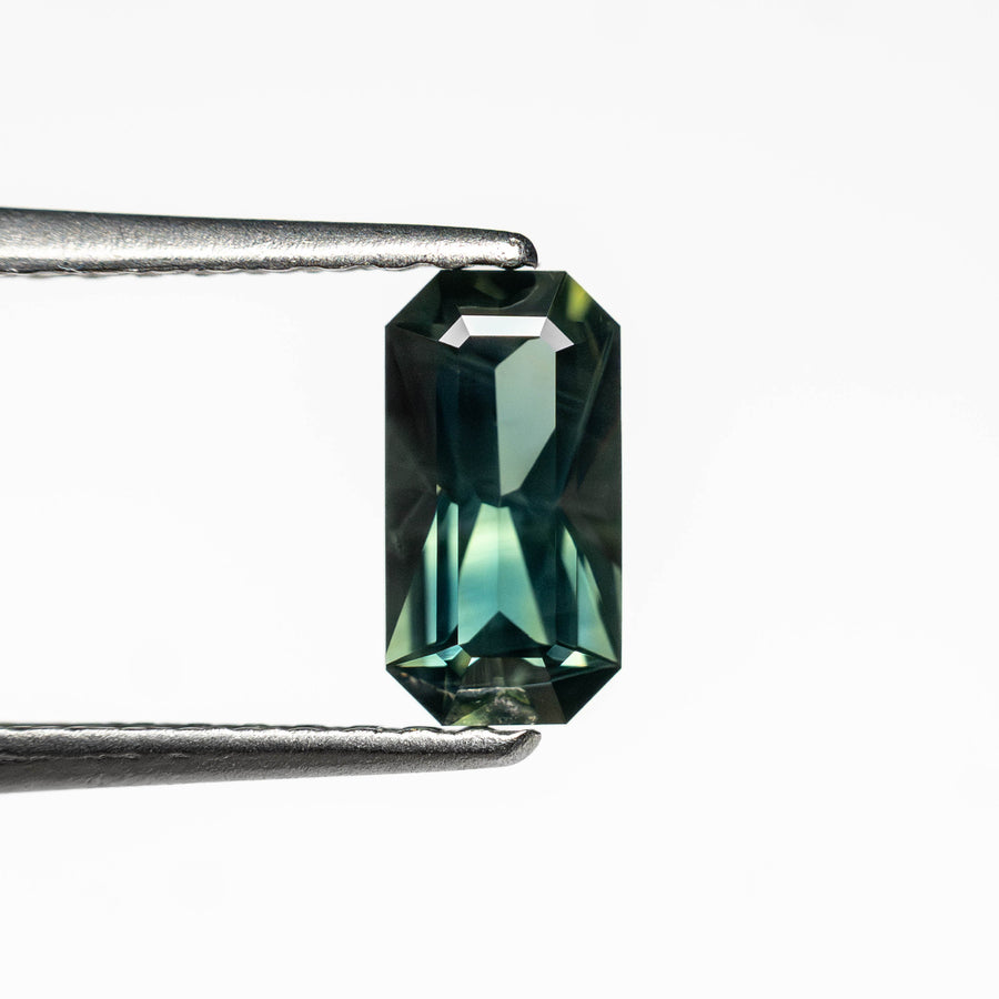 The 0.60ct 6.93x3.63x2.58mm Cut Corner Rectangle Step Cut Sapphire 27336-39 by East London jeweller Rachel Boston | Discover our collections of unique and timeless engagement rings, wedding rings, and modern fine jewellery. - Rachel Boston Jewellery