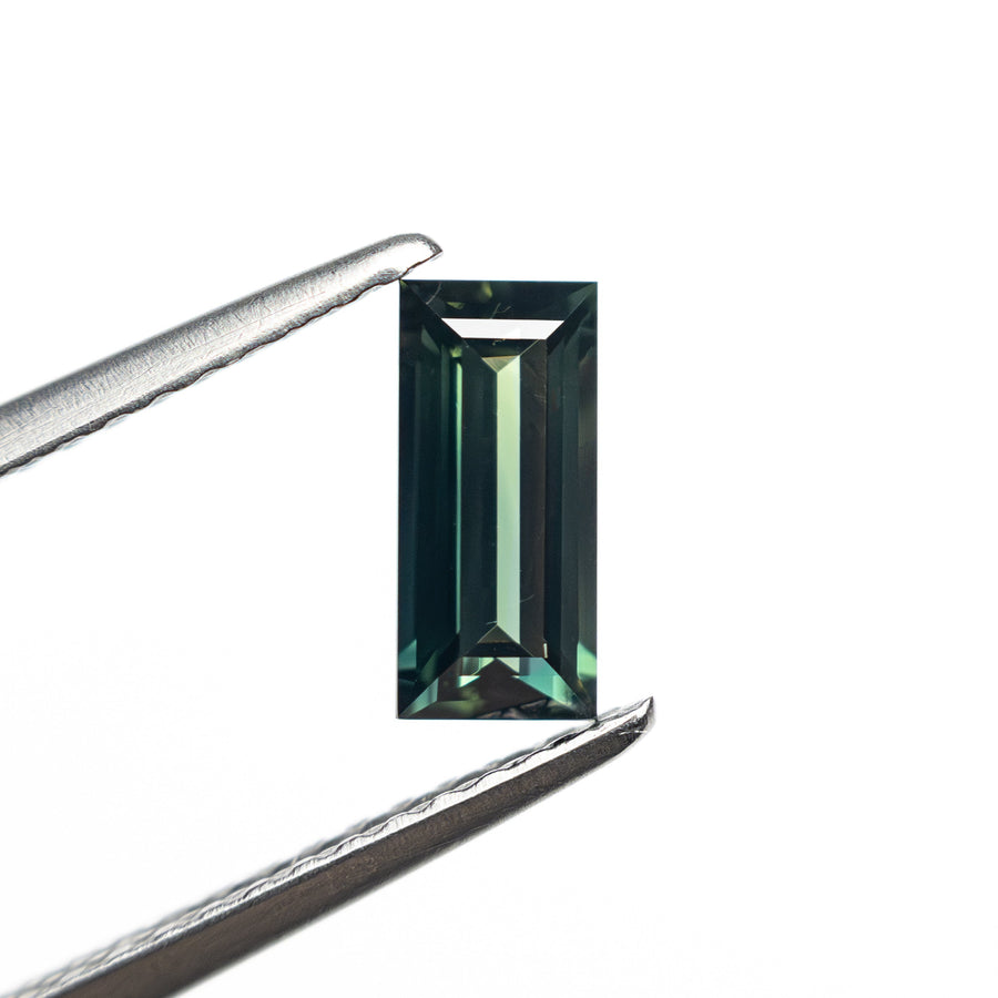 The 0.71ct 7.14x3.43x2.45mm Rectangle Step Cut Sapphire 27336-46 by East London jeweller Rachel Boston | Discover our collections of unique and timeless engagement rings, wedding rings, and modern fine jewellery. - Rachel Boston Jewellery