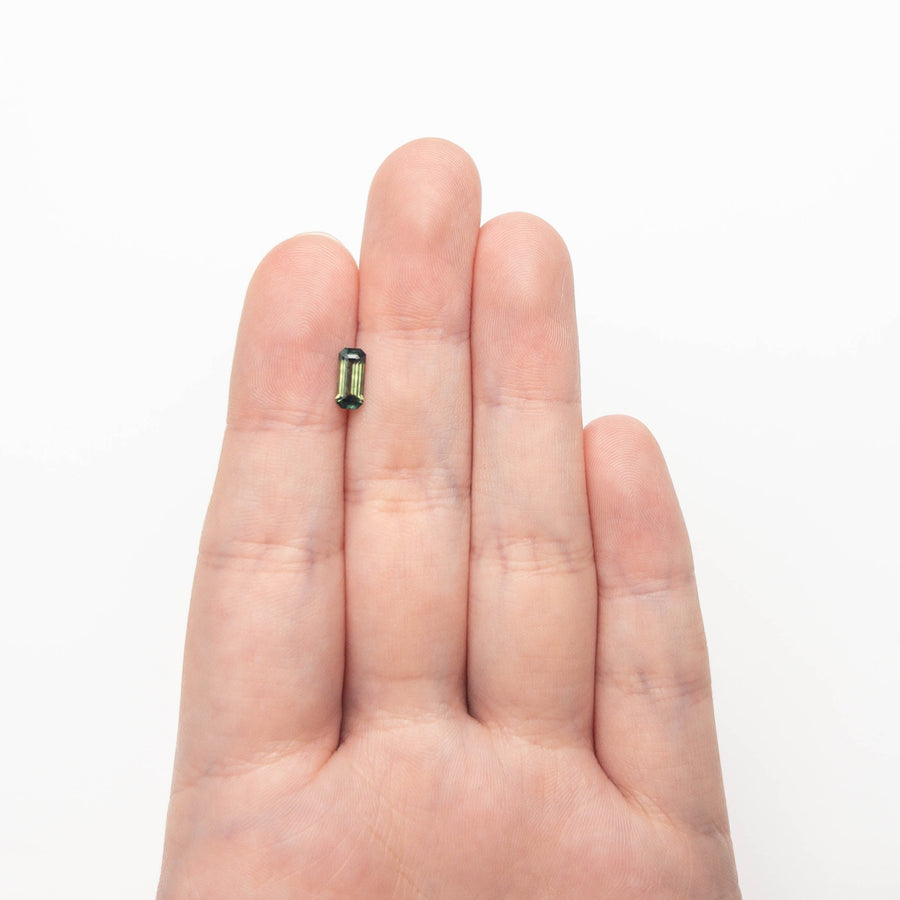 The 0.78ct 8.00x3.57x2.63mm Cut Corner Rectangle Step Cut Sapphire 27336-56 by East London jeweller Rachel Boston | Discover our collections of unique and timeless engagement rings, wedding rings, and modern fine jewellery. - Rachel Boston Jewellery