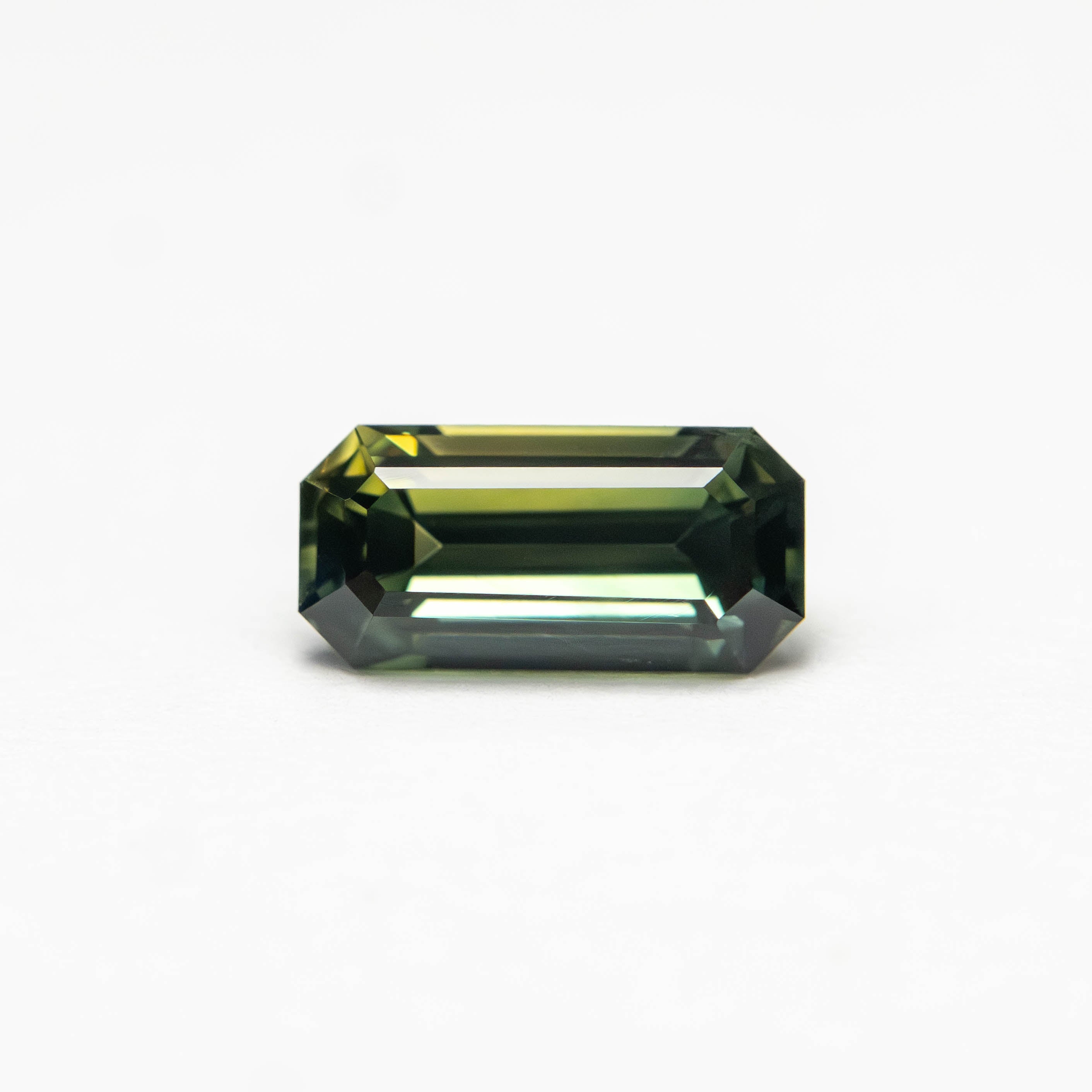 The 0.82ct 7.17x3.48x3.18mm Cut Corner Rectangle Step Cut Sapphire 27336-57 by East London jeweller Rachel Boston | Discover our collections of unique and timeless engagement rings, wedding rings, and modern fine jewellery.