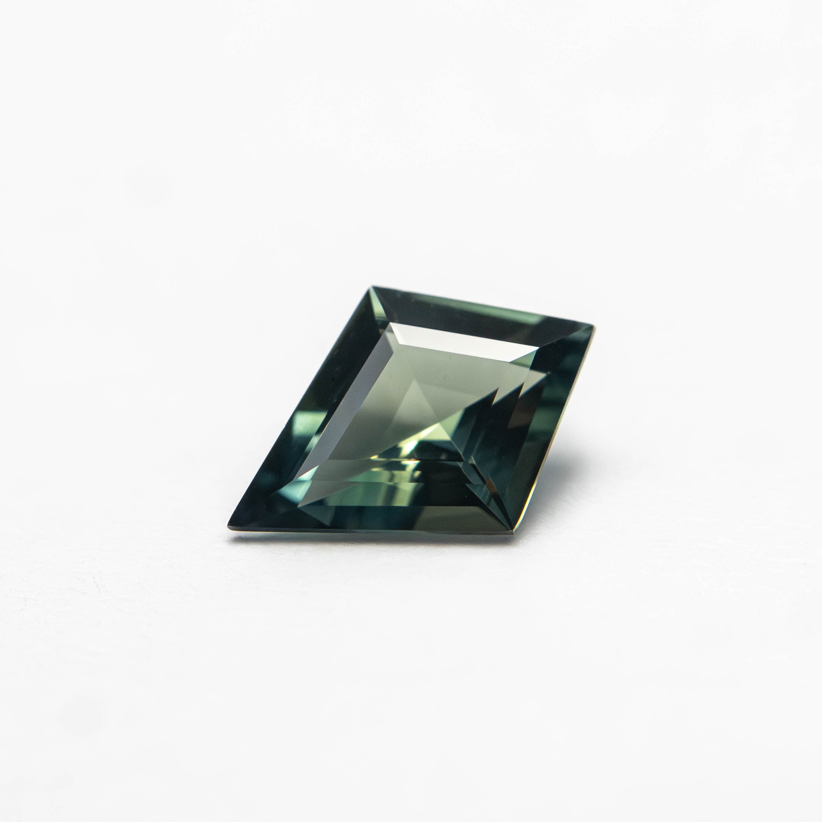 The 0.54ct 7.68x5.44x2.64mm Kite Step Cut Sapphire 27363-14 by East London jeweller Rachel Boston | Discover our collections of unique and timeless engagement rings, wedding rings, and modern fine jewellery.