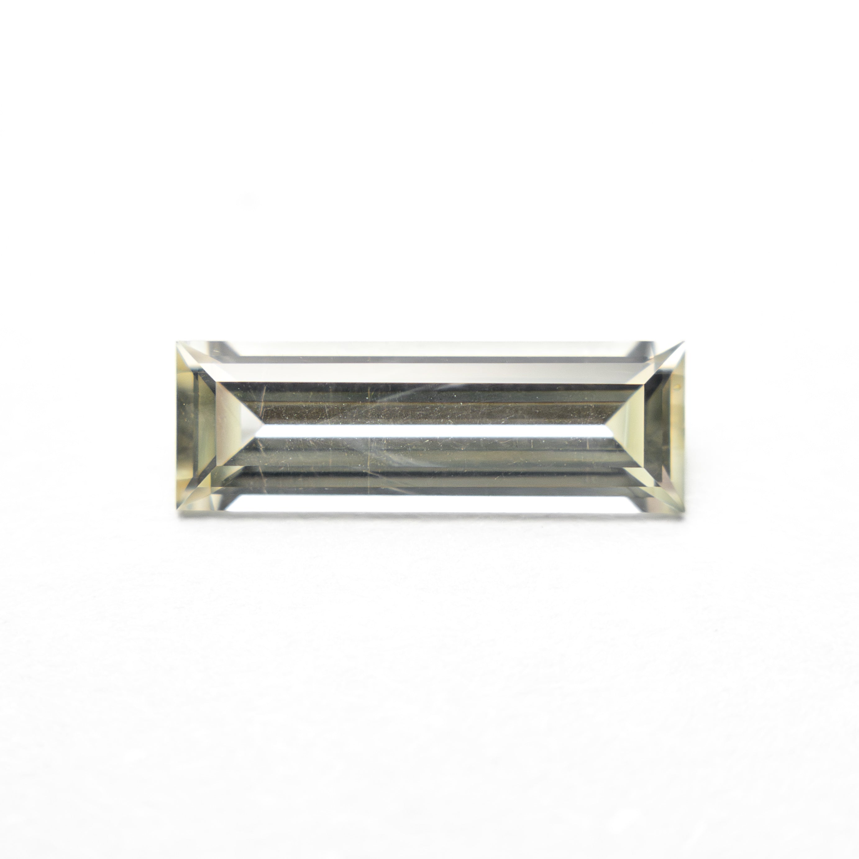 The 0.84ct 9.95x3.36x2.17mm Baguette Step Cut Sapphire 27719-01 by East London jeweller Rachel Boston | Discover our collections of unique and timeless engagement rings, wedding rings, and modern fine jewellery.