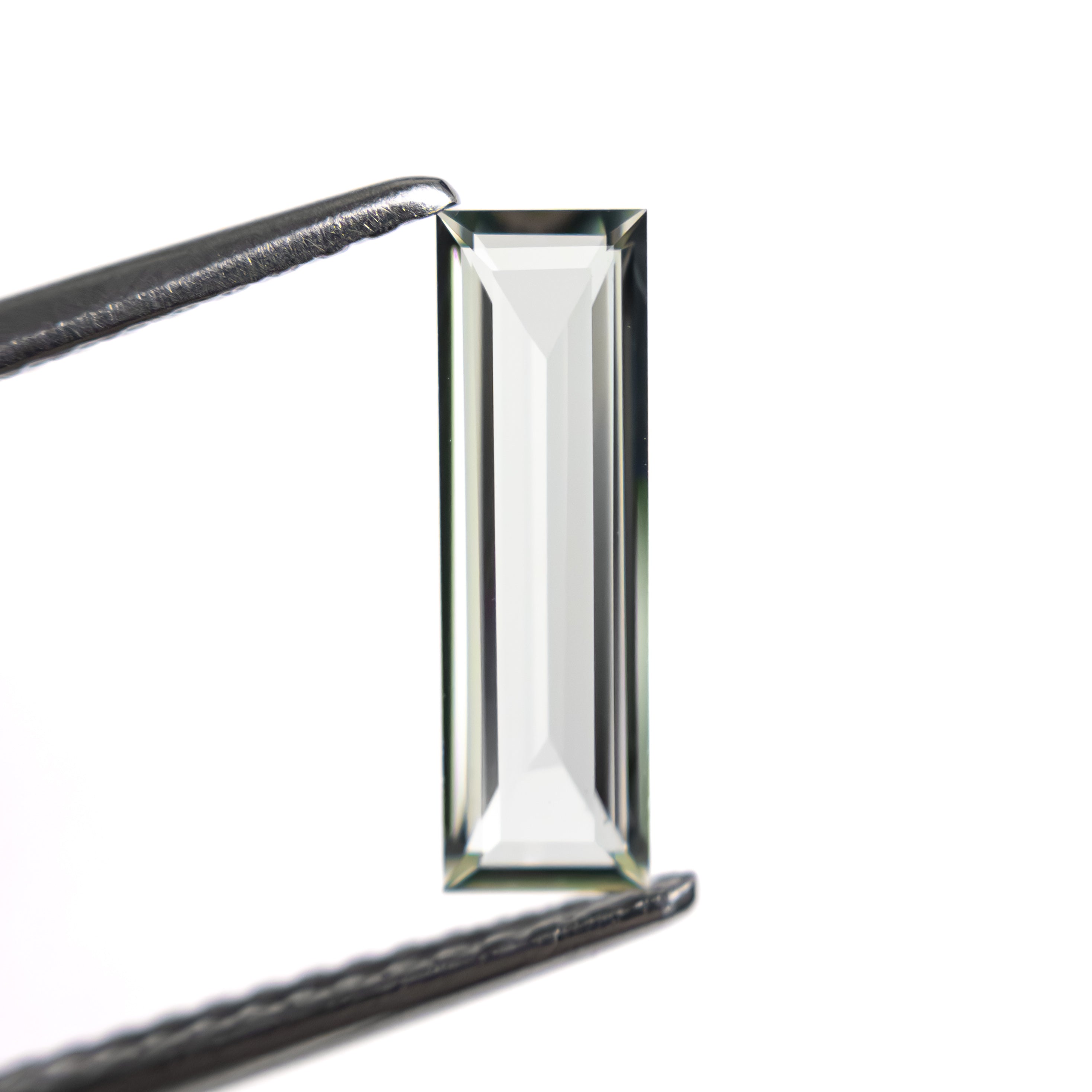 The 0.81ct 11.41x3.48x1.63mm Baguette Step Cut Sapphire 27720-05 by East London jeweller Rachel Boston | Discover our collections of unique and timeless engagement rings, wedding rings, and modern fine jewellery.