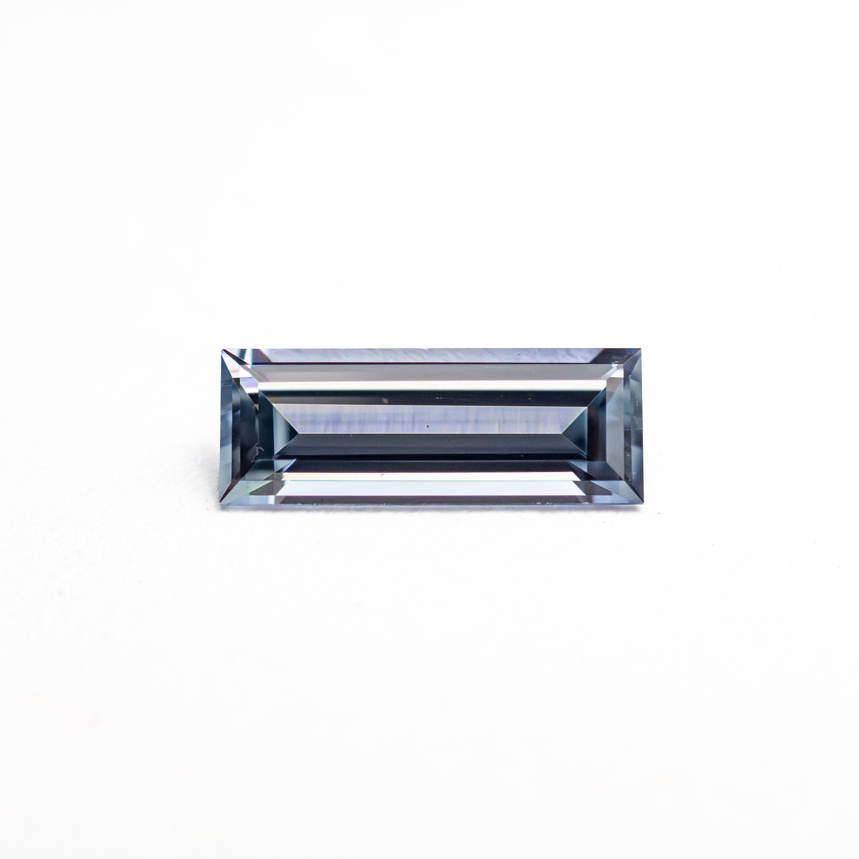 The 0.57ct 8.05x3.02x2.09mm Baguette Step Cut Sapphire 27721-02 by East London jeweller Rachel Boston | Discover our collections of unique and timeless engagement rings, wedding rings, and modern fine jewellery.