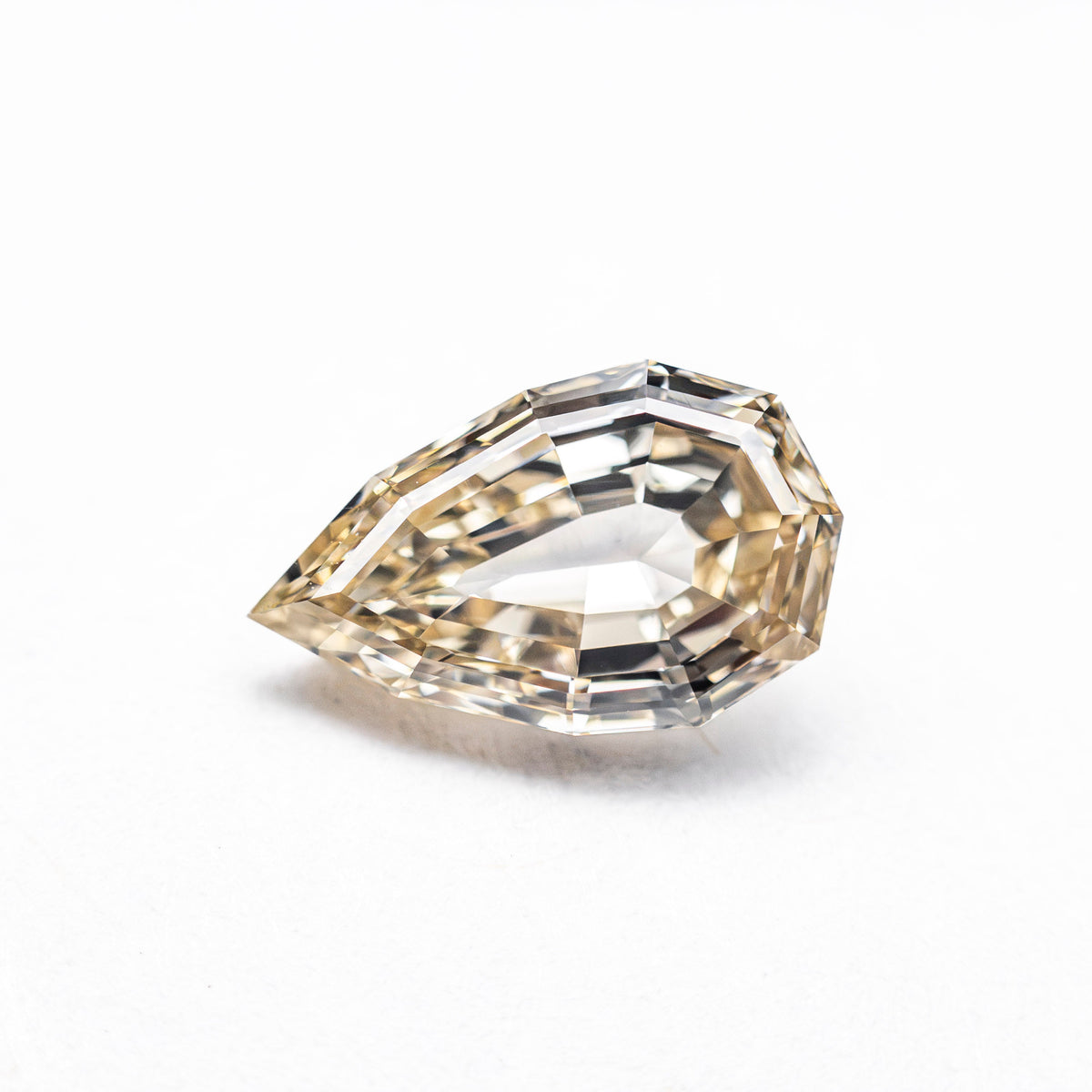 The 1.21ct 9.11x5.57x3.36mm VVS2 Fancy Light Yellowish Brown Geo Pear Step Cut 28047-01 by East London jeweller Rachel Boston | Discover our collections of unique and timeless engagement rings, wedding rings, and modern fine jewellery.
