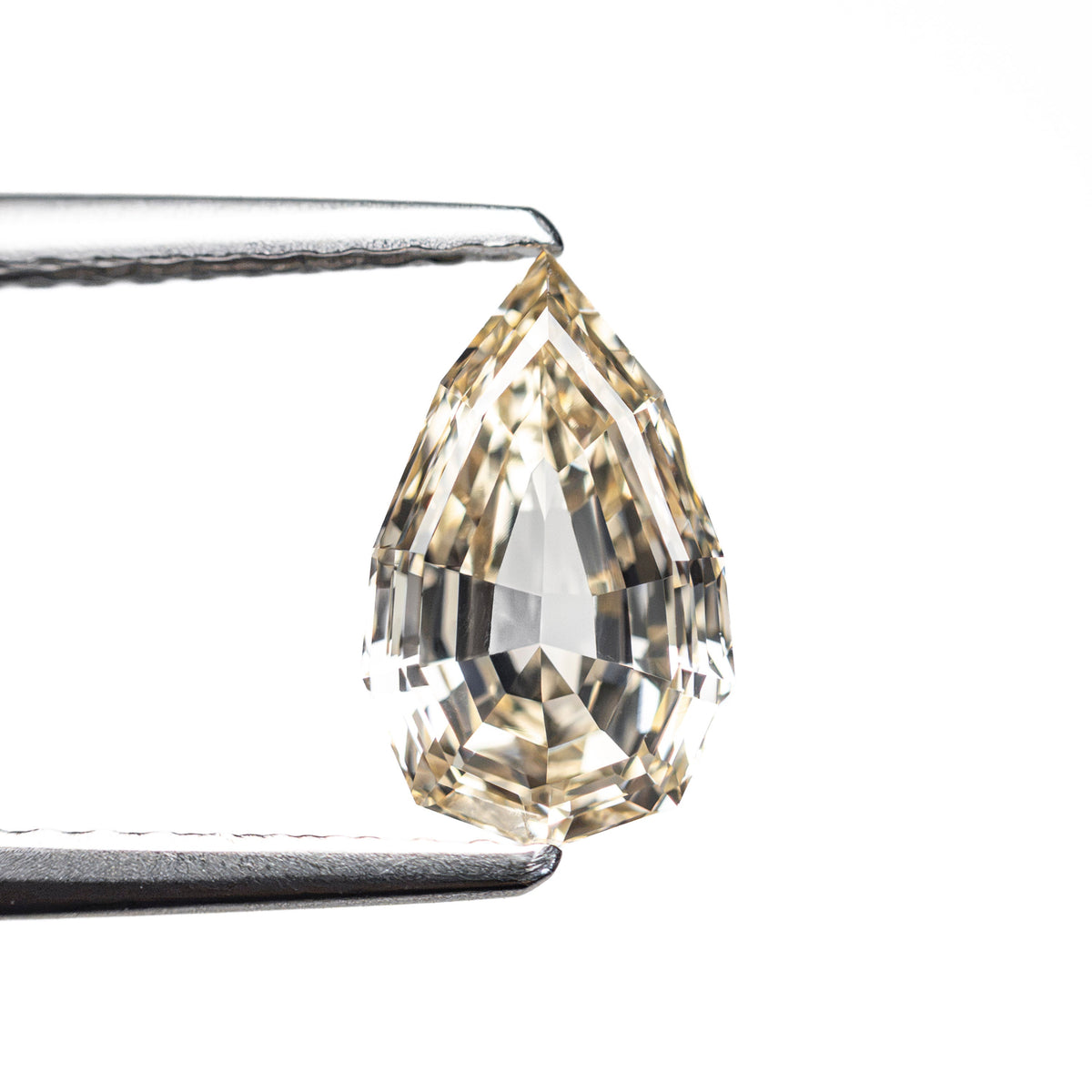 The 1.21ct 9.11x5.57x3.36mm VVS2 Fancy Light Yellowish Brown Geo Pear Step Cut 28047-01 by East London jeweller Rachel Boston | Discover our collections of unique and timeless engagement rings, wedding rings, and modern fine jewellery.