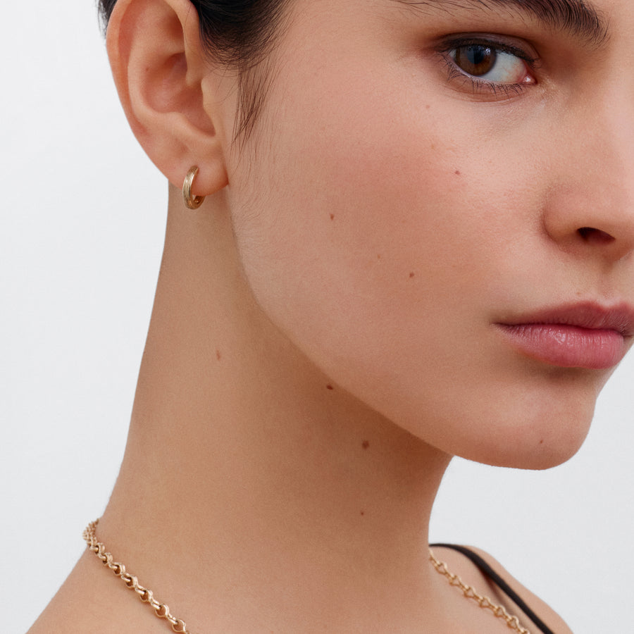 The 12.8mm Engraved Lines Huggie Hoop Earrings by East London jeweller Rachel Boston | Discover our collections of unique and timeless engagement rings, wedding rings, and modern fine jewellery. - Rachel Boston Jewellery