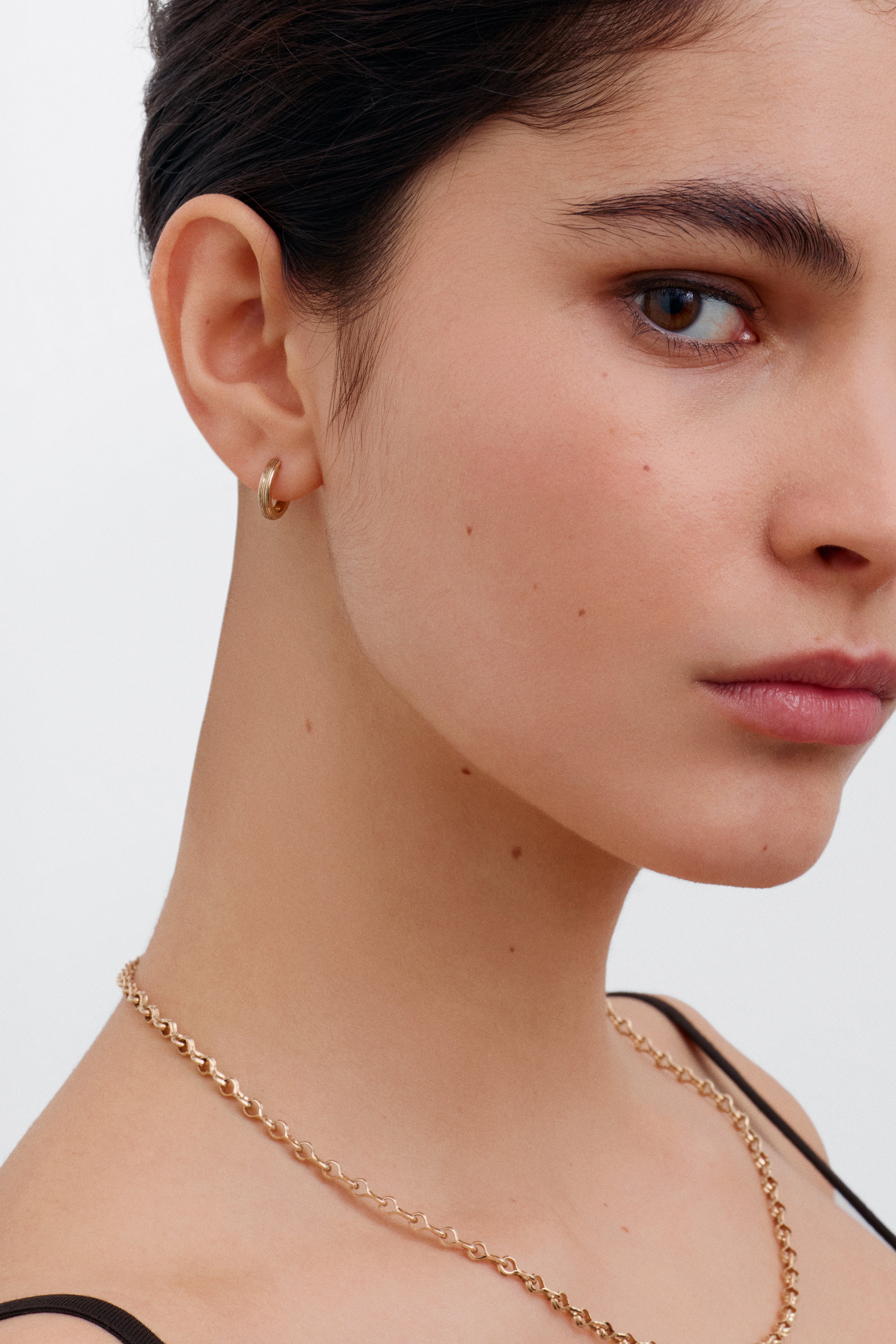 The 12.8mm Engraved Lines Huggie Hoop Earrings by East London jeweller Rachel Boston | Discover our collections of unique and timeless engagement rings, wedding rings, and modern fine jewellery.
