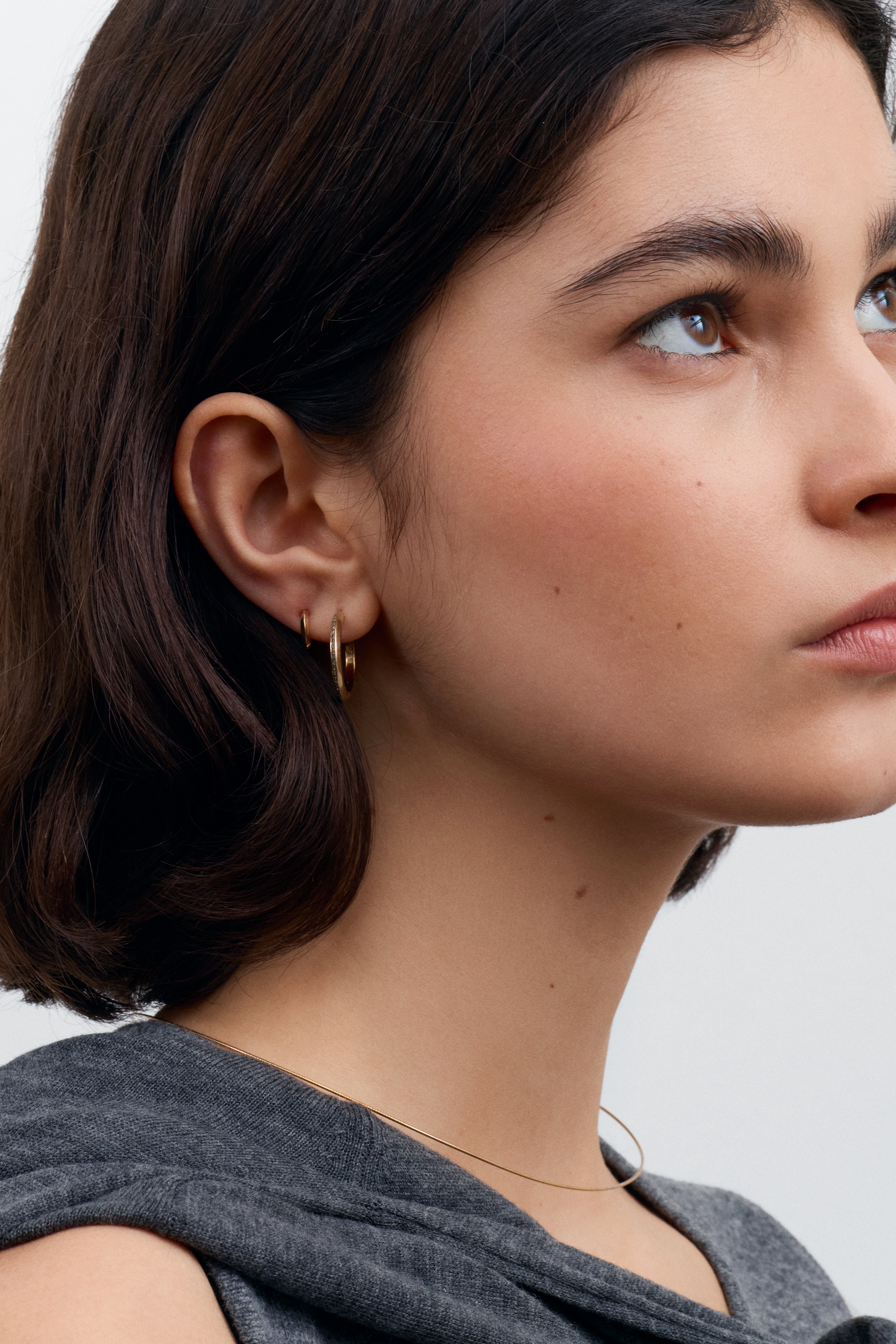The 10mm Knife Edge Huggie Hoop Earrings by East London jeweller Rachel Boston | Discover our collections of unique and timeless engagement rings, wedding rings, and modern fine jewellery.